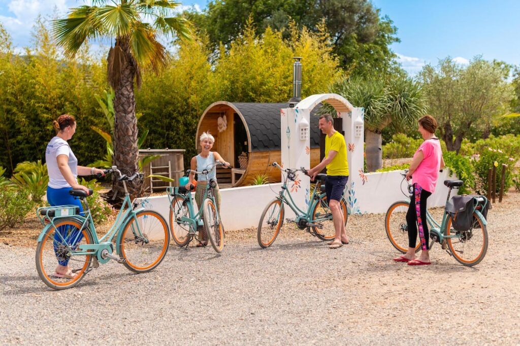 A group of friends or guests riding rental electric bikes on a sunny trail at Seeds of Silence in the Algarve.