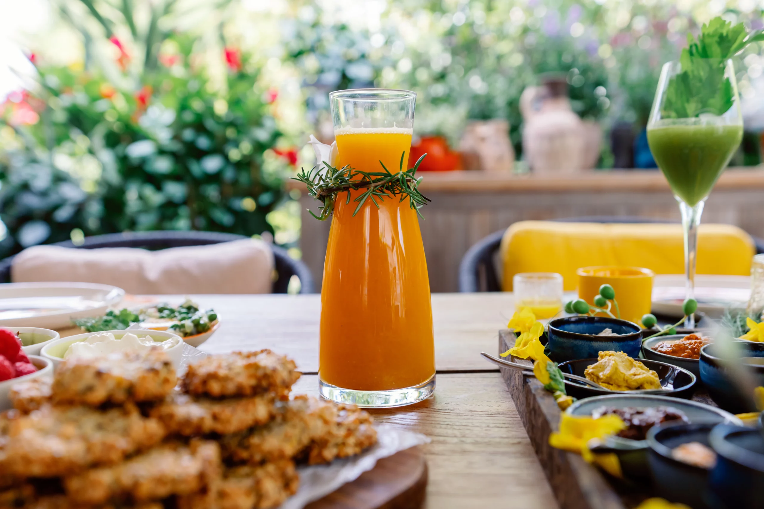 A close-up of a freshly baked gourmet flatbread topped with fresh green herbs and savory ingredients, served on a rustic wooden board at the Seeds of Silence wellness retreat in Algarve, Portugal.